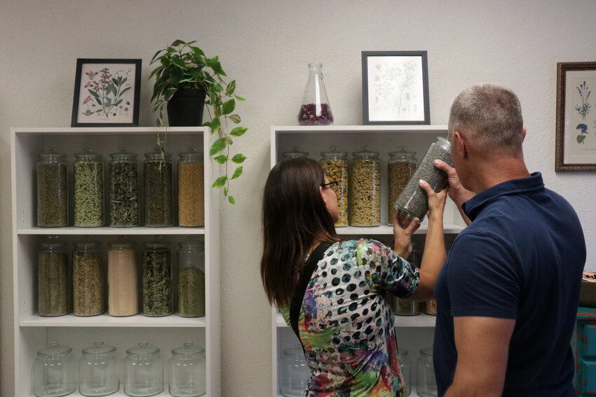 Visitors examine the teas and herbs on display at Bridget's Botanicals, a new apothecary and herbalism education shop in downtown Littleton.